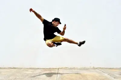 Homem pulando no ar enquanto tira uma selfie