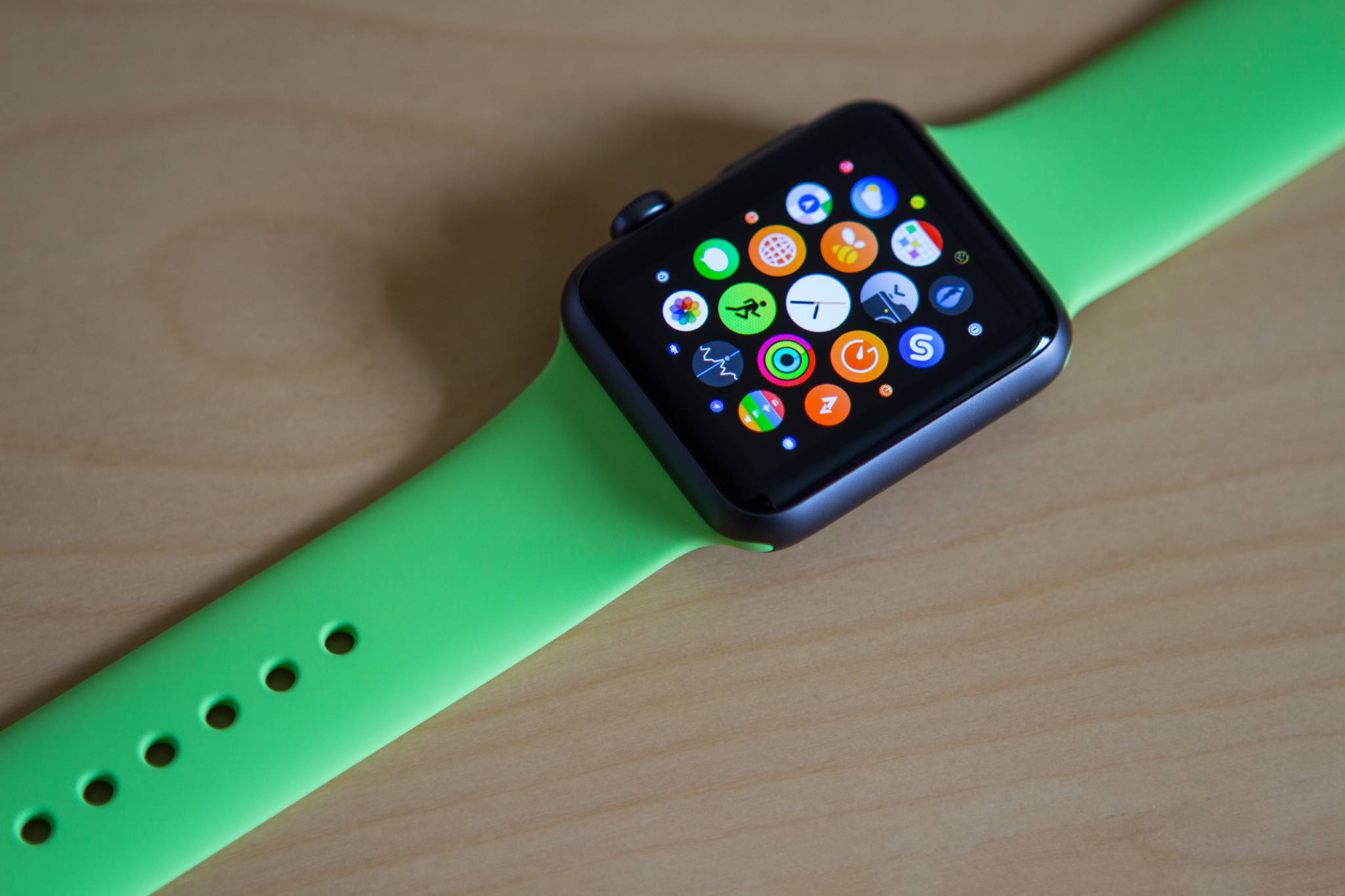 Apple Watch com pulseira verde Sport em uma mesa