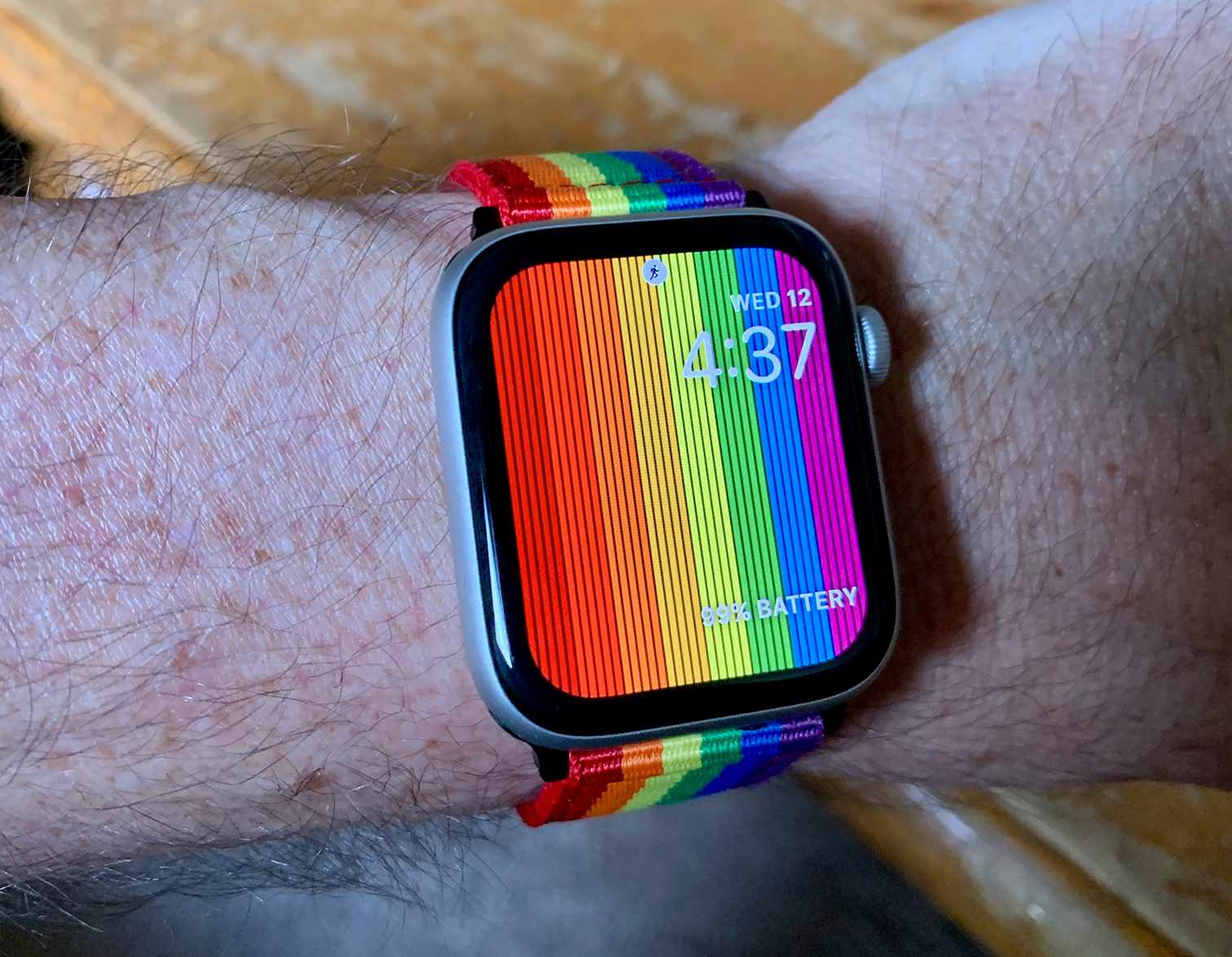 Apple Watch com pulseira de arco-íris Pride e mostrador do relógio