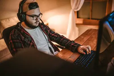 Homem barbudo jogando videogame no computador em casa