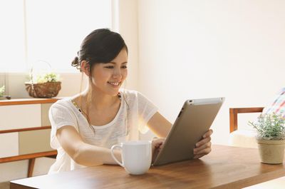 Mulher jovem usando um tablet para acessar seu e-mail AIM