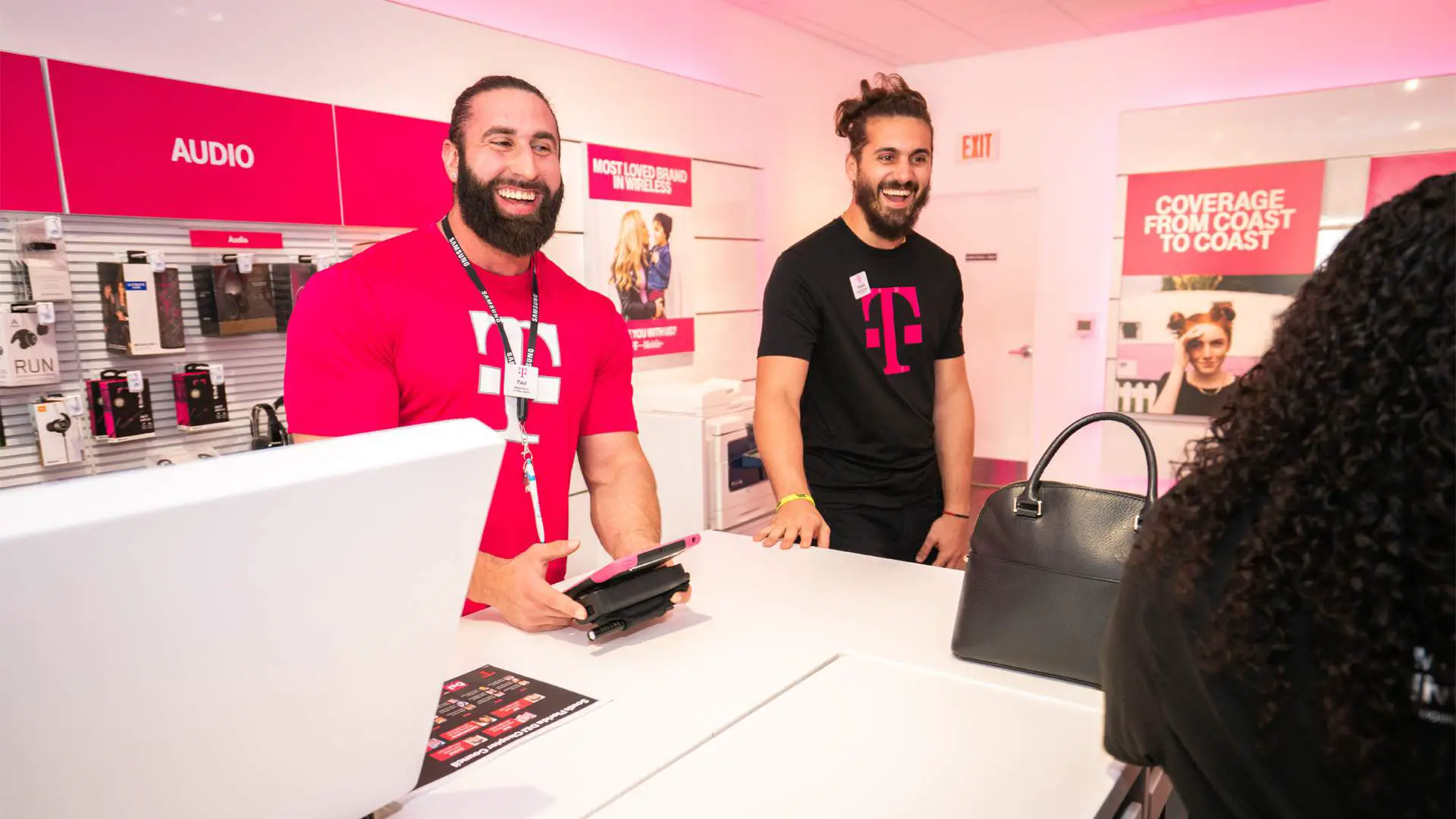 Funcionários da T-Mobile em uma agência cumprimentando clientes.