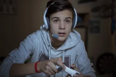 Jovem adolescente jogando videogame usando um fone de ouvido