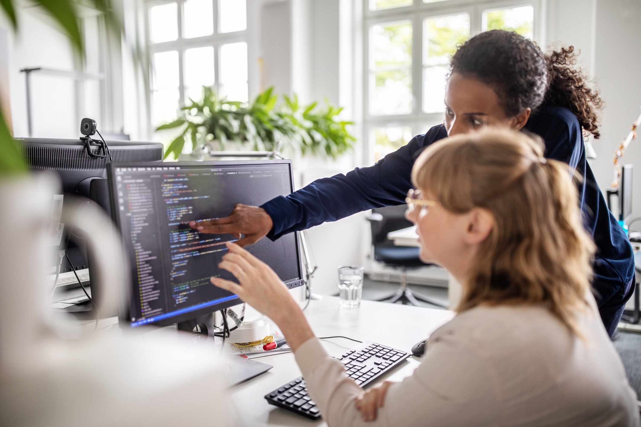 Empresários discutindo código na tela do computador. 