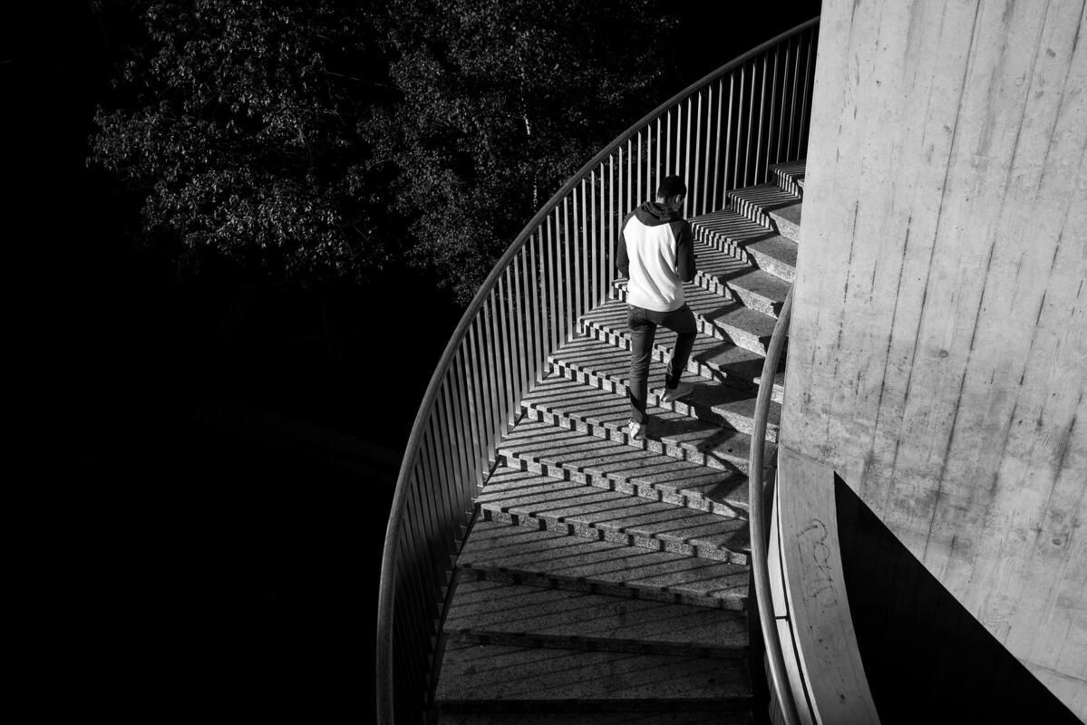 Foto em preto e branco de um homem subindo escadas tirada com a Leica Q2 Monochrom