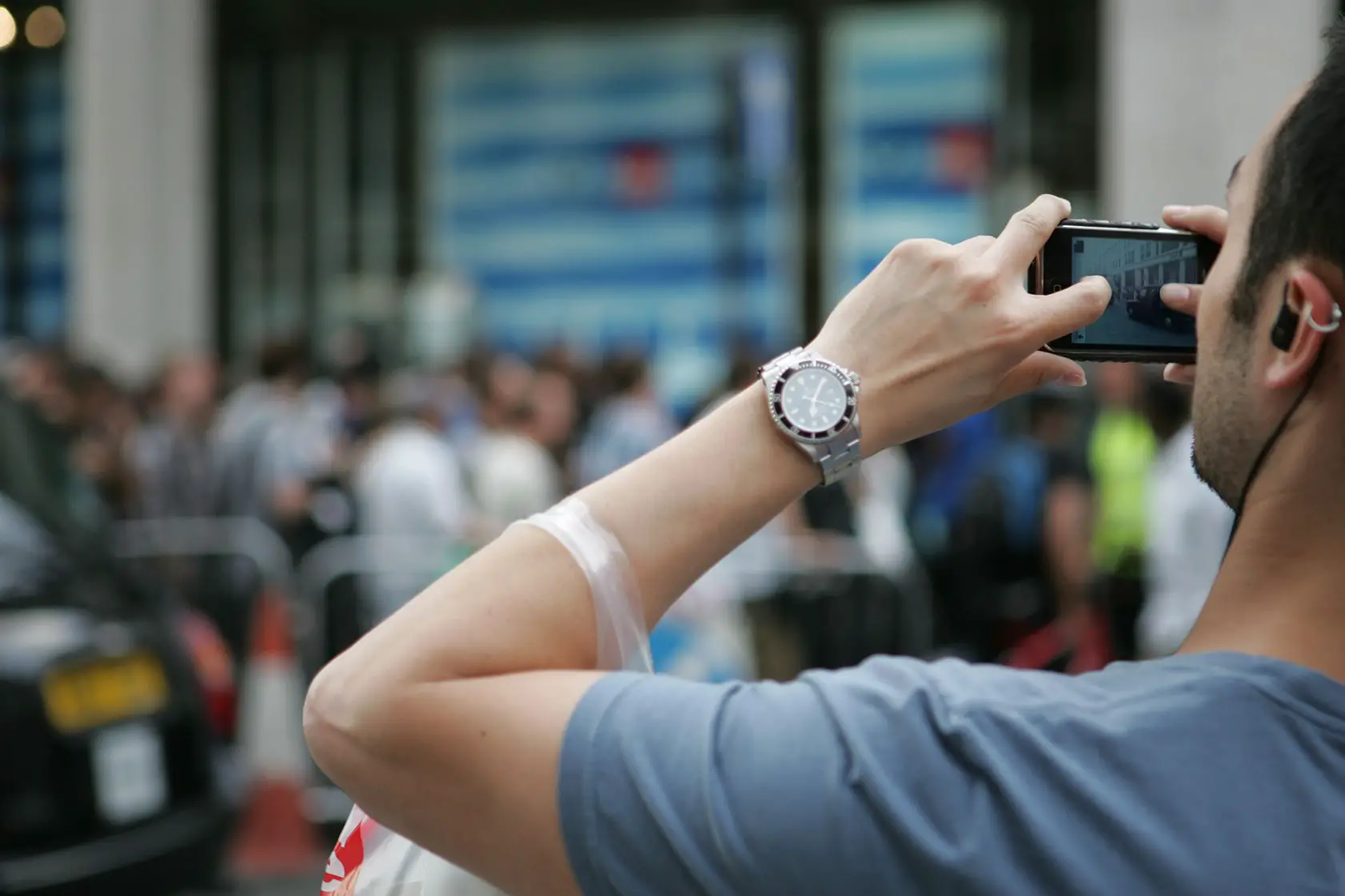 Pessoa tirando uma foto com o iPhone tirando fotos na rua