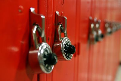 Fechaduras combinadas em uma fileira de armários vermelhos de colégio