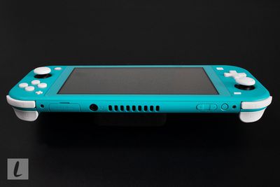 Um console de jogos Nintendo Switch Lite em um fundo preto