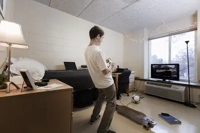 Aluno jogando videogame no dormitório