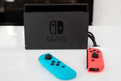 Um console Nintendo Switch fica em uma superfície branca.