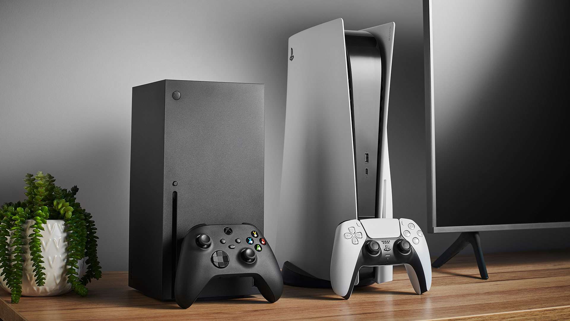 Um Xbox Series X e um PS 5 configurados lado a lado em um centro de entretenimento com uma TV.