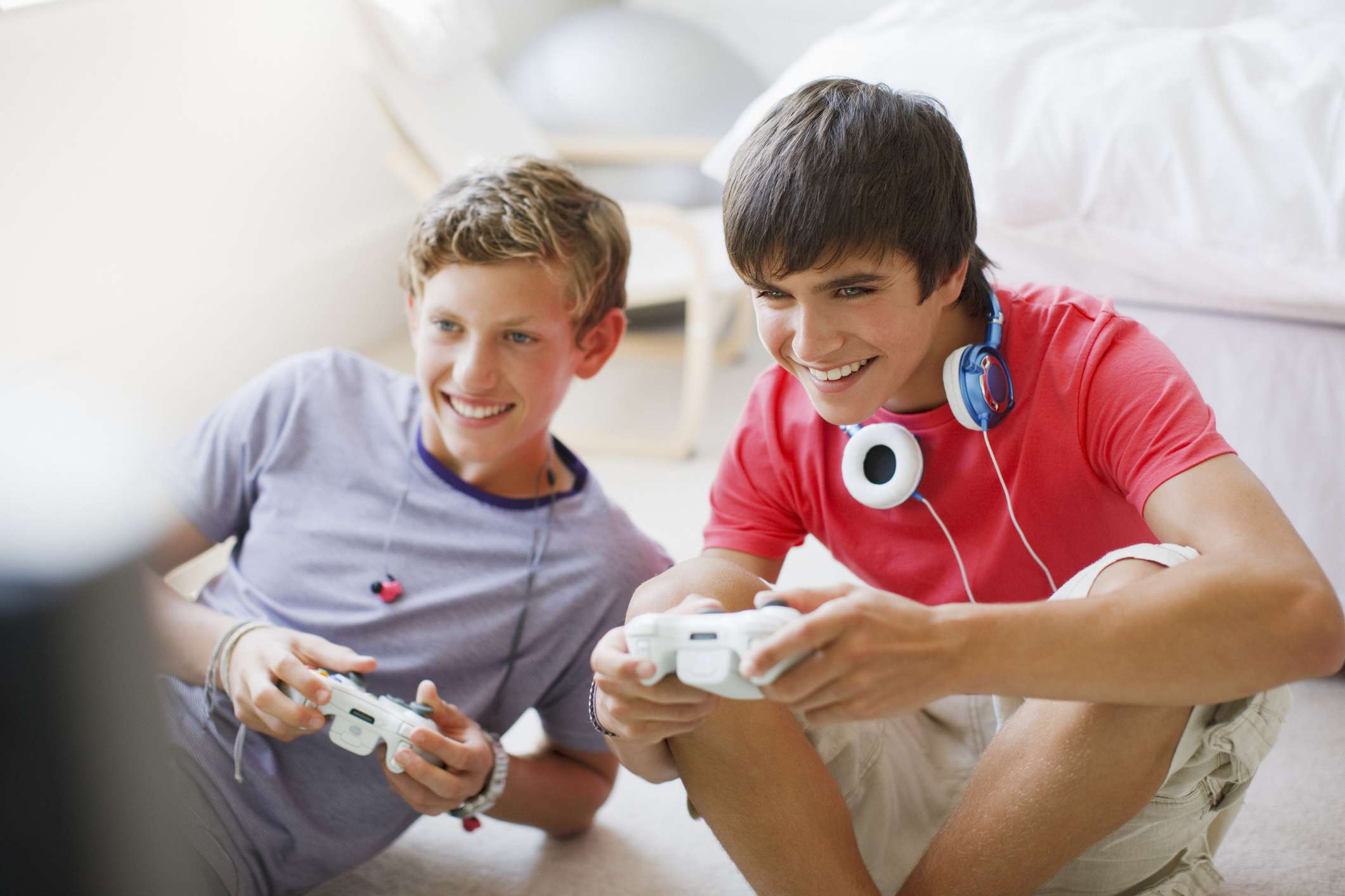 Dois adolescentes jogando videogame. 