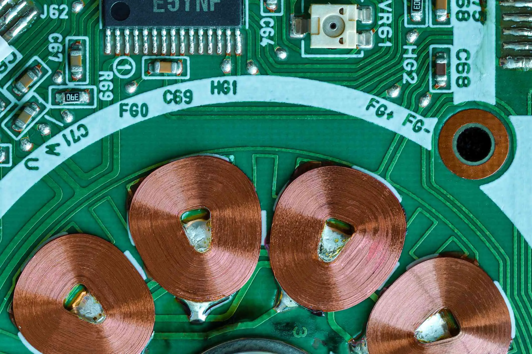 Filmado de cima de uma placa de circuito mostrando bobinas de cobre