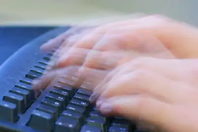 Imagem de mãos movendo-se rapidamente sobre um teclado.