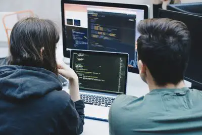 Designers usando monitor com MacBook Pro