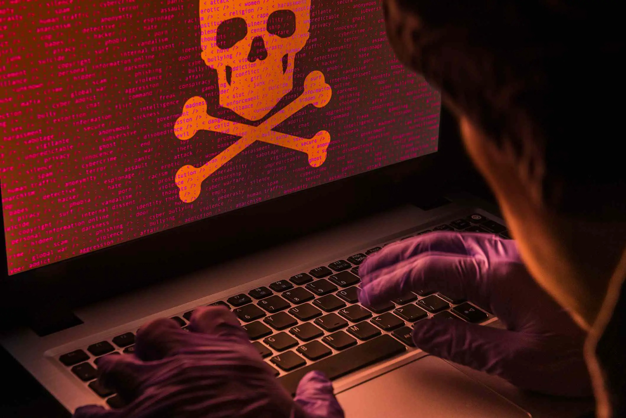 Imagens de um hacker trabalhando em um laptop.