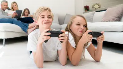 Um menino e uma menina jogando videogame off-line no console de jogos Xbox One.