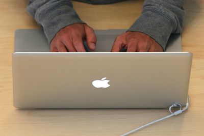 Pessoa digitando no MacBook na Apple Store