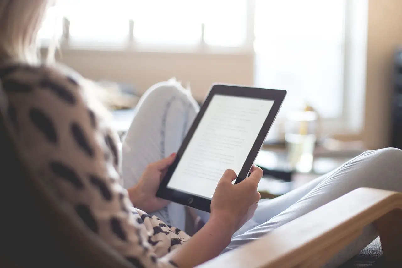 Foto de uma mulher lendo um e-book em um tablet