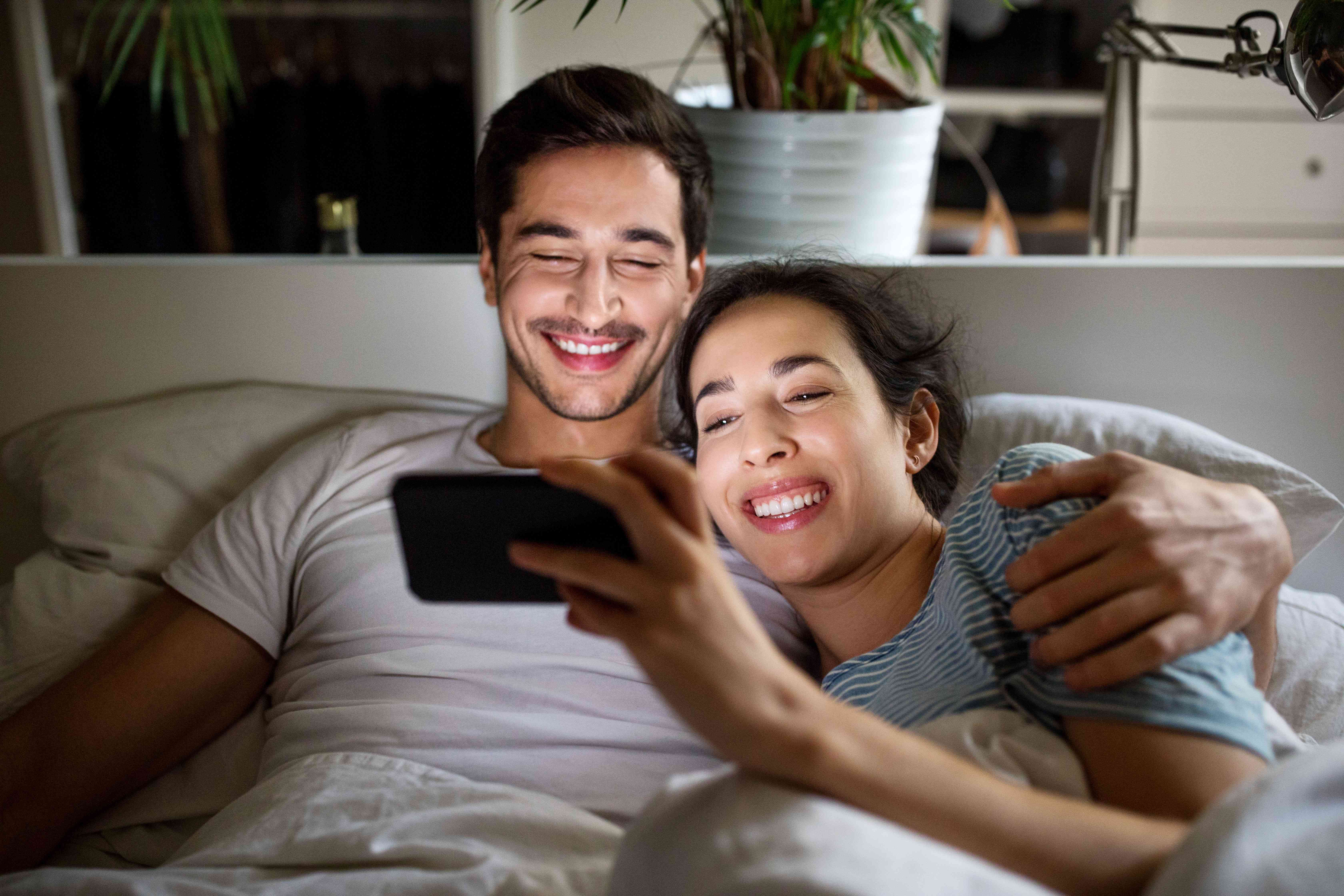 Homem e mulher assistindo a um vídeo em um smartphone