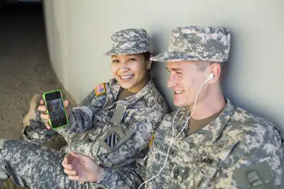 Militares em serviço ativo relaxando com seu telefone e música.
