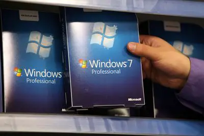 Mão segurando o software da caixa do Windows 7 em um display de varejo