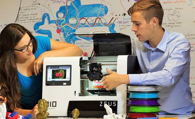 Homem e mulher com impressora 3D e filamento 3D extra
