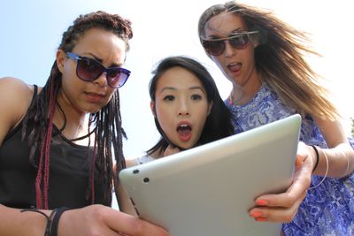 Um grupo de amigos segurando um tablet iPad