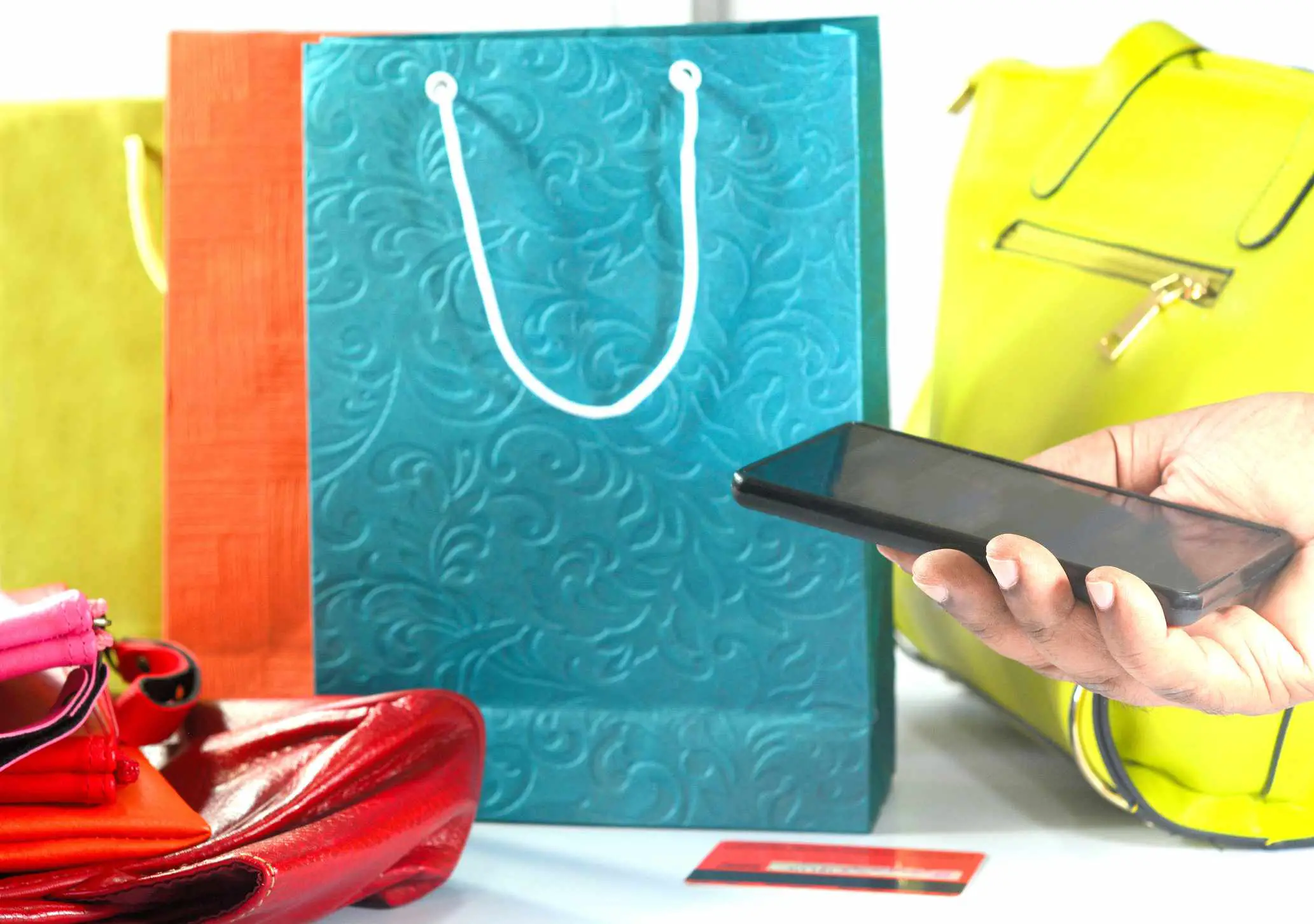 Conceito de compras online com sacolas, bolsas e carteiras compradas com telefone inteligente.