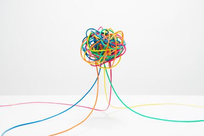Muitos fios coloridos se juntando em uma bola com nós