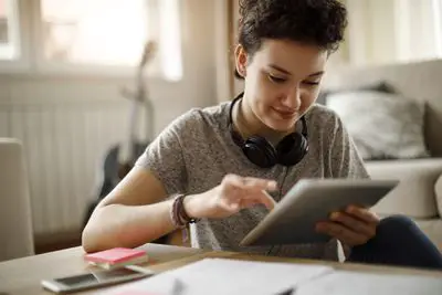 Um aluno usando um tablet digital em casa