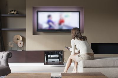Pessoa assistindo televisão na sala de estar
