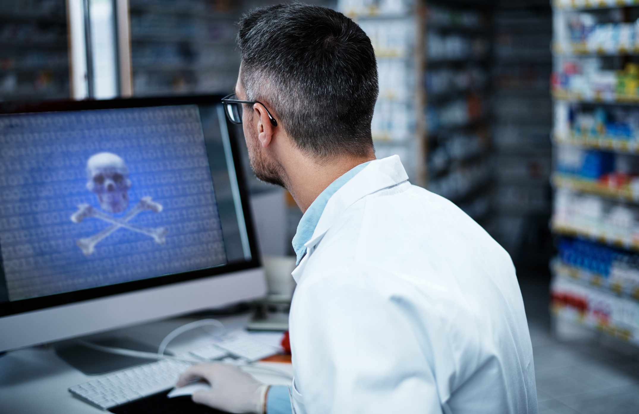 Um médico olhando para uma tela de computador que exibe ransomware.