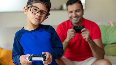 Menino e pai jogando videogame Xbox One