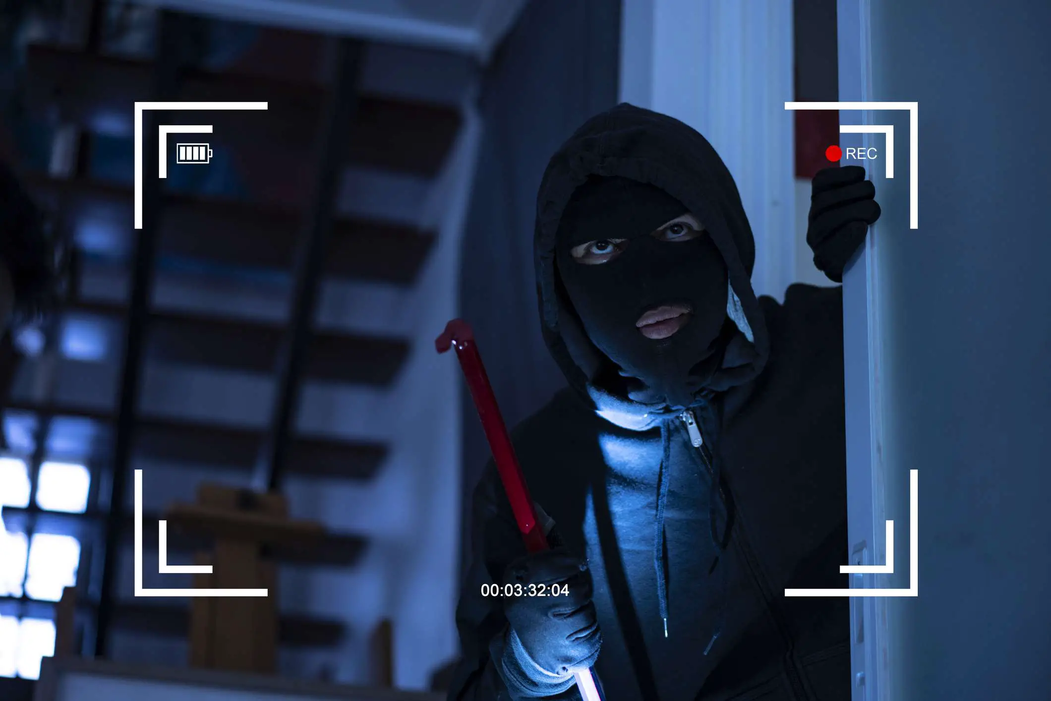 Imagem CCTV de um ladrão entrando em casa pela janela com um pé-de-cabra