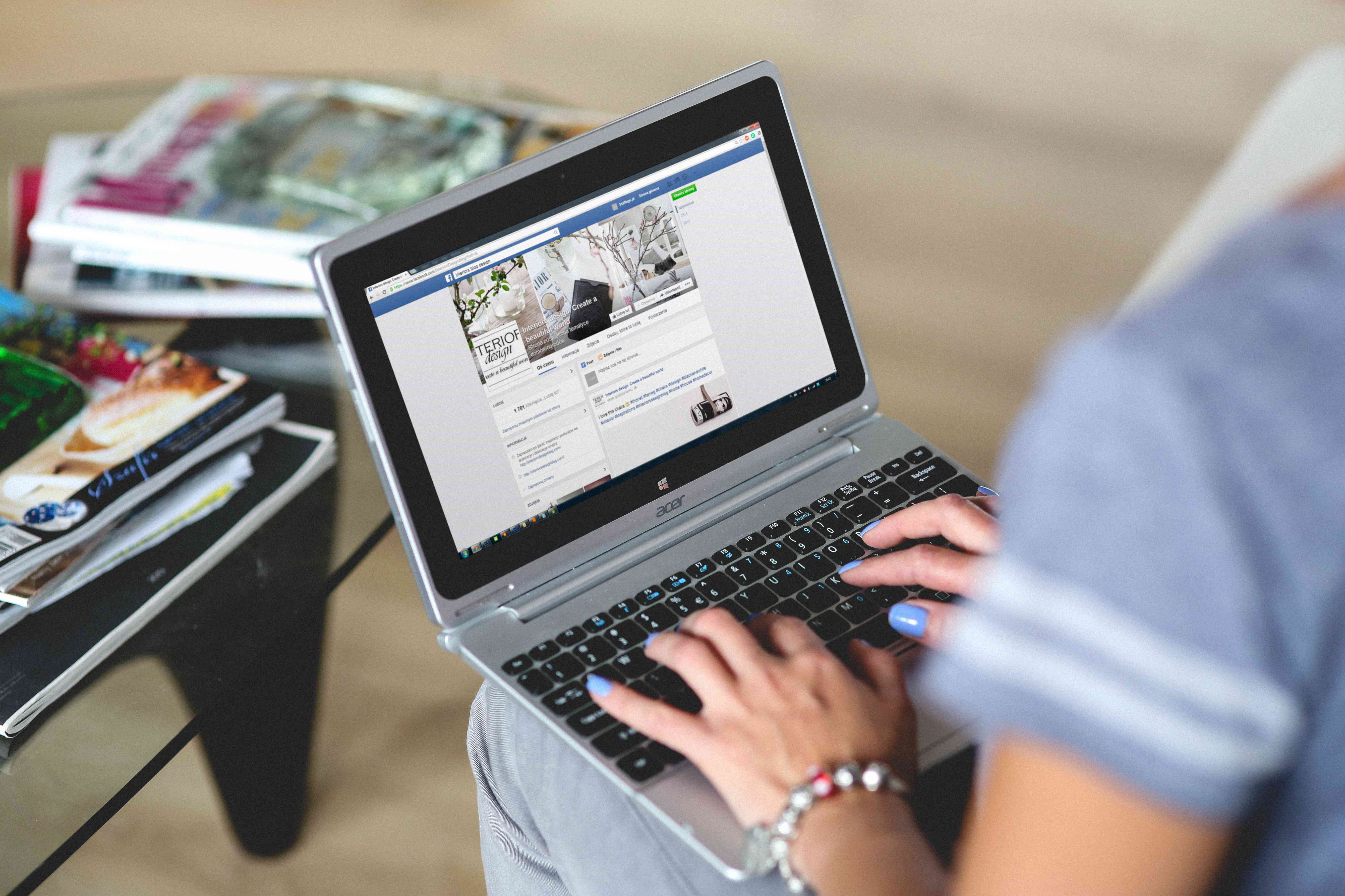 Uma imagem de uma mulher olhando para uma página do Facebook em um laptop.