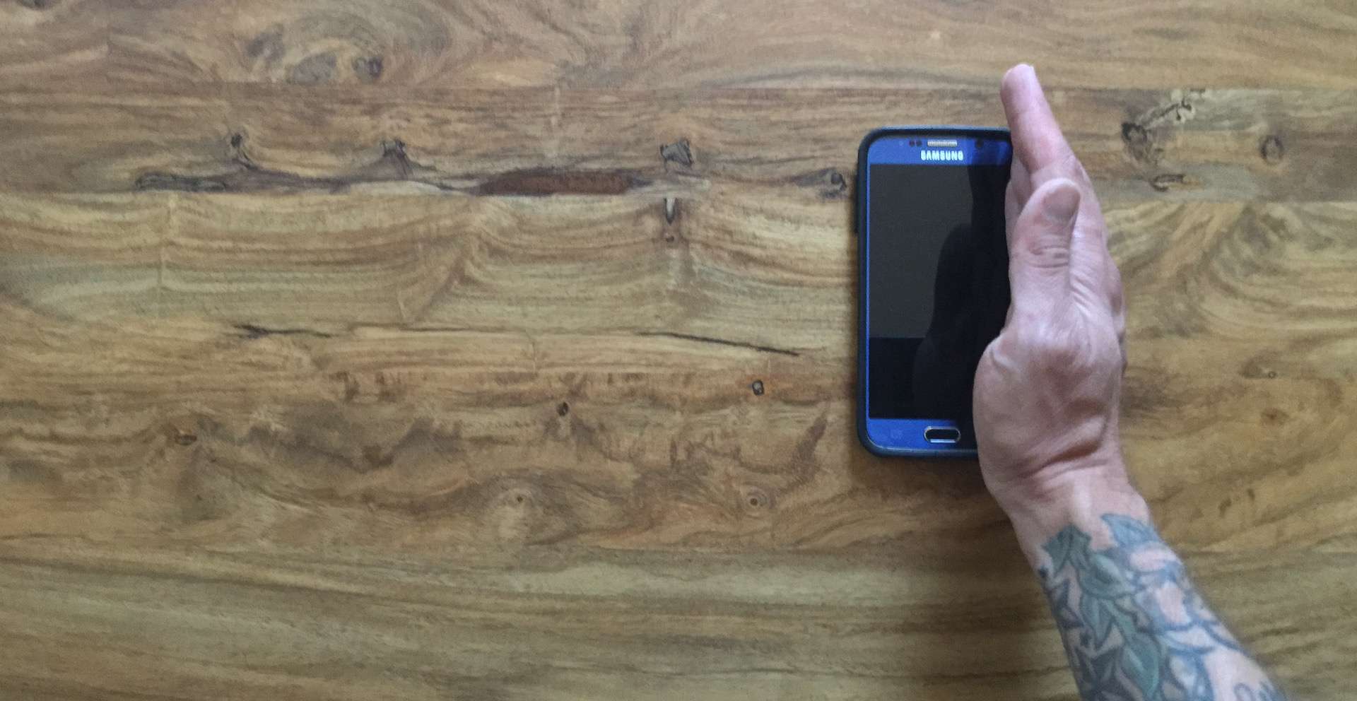 A mão de um homem está vertical na borda de um Samsung S6.