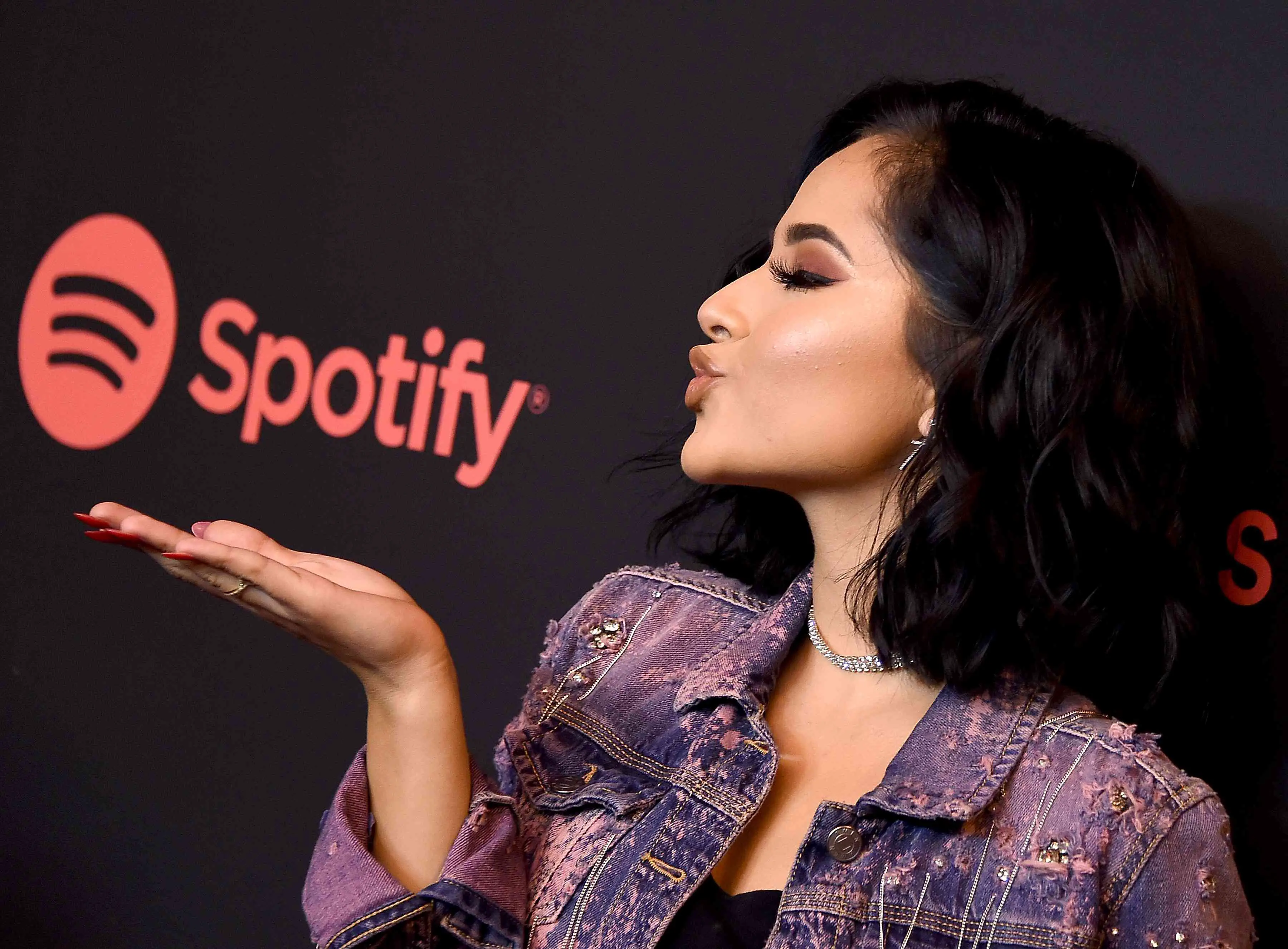 Mulher mandando um beijo para um logotipo do Spotify