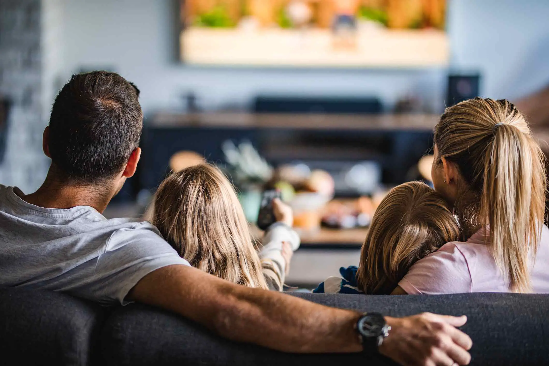 Família assistindo tv junta