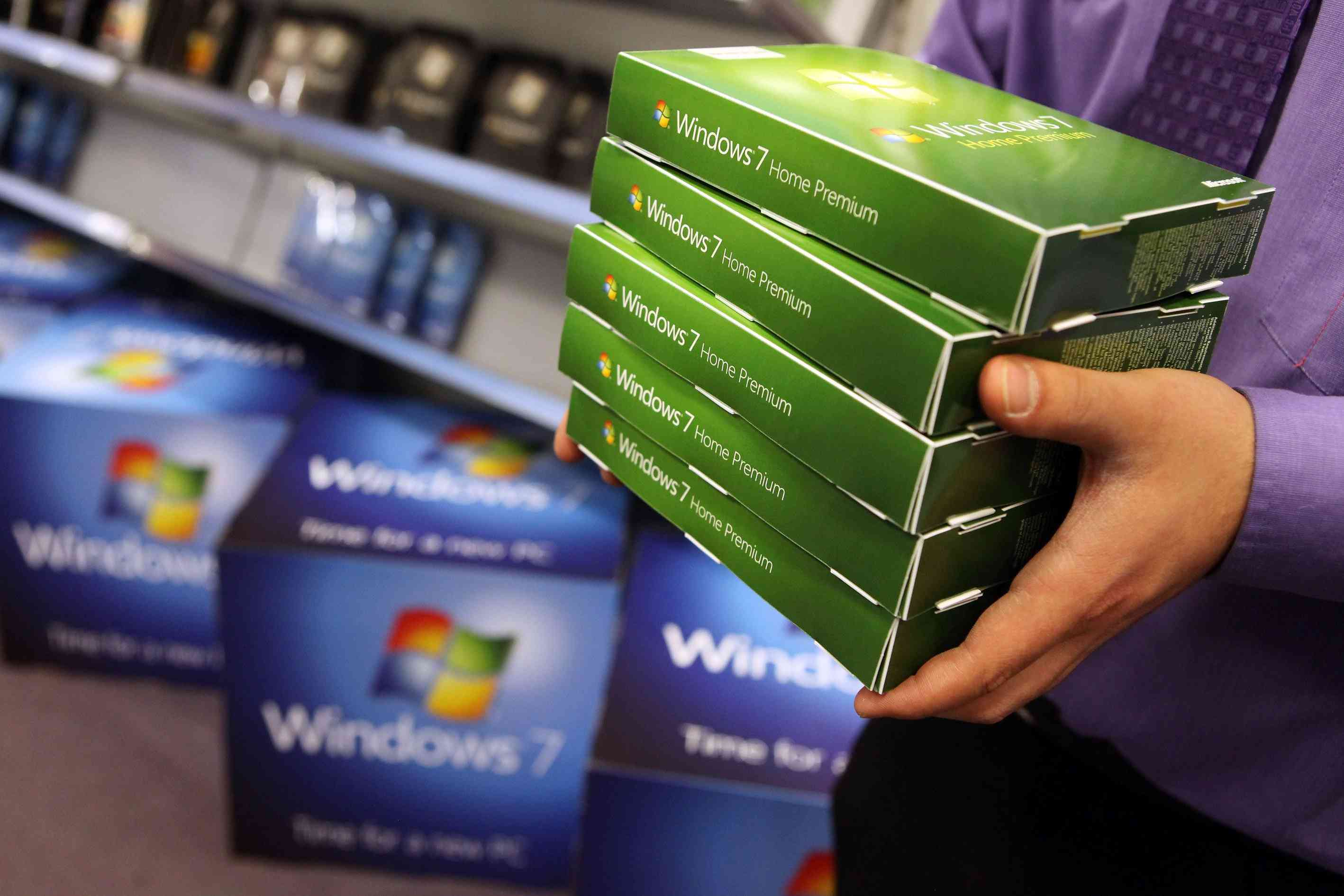 Pessoa segurando caixas de software do Windows 7