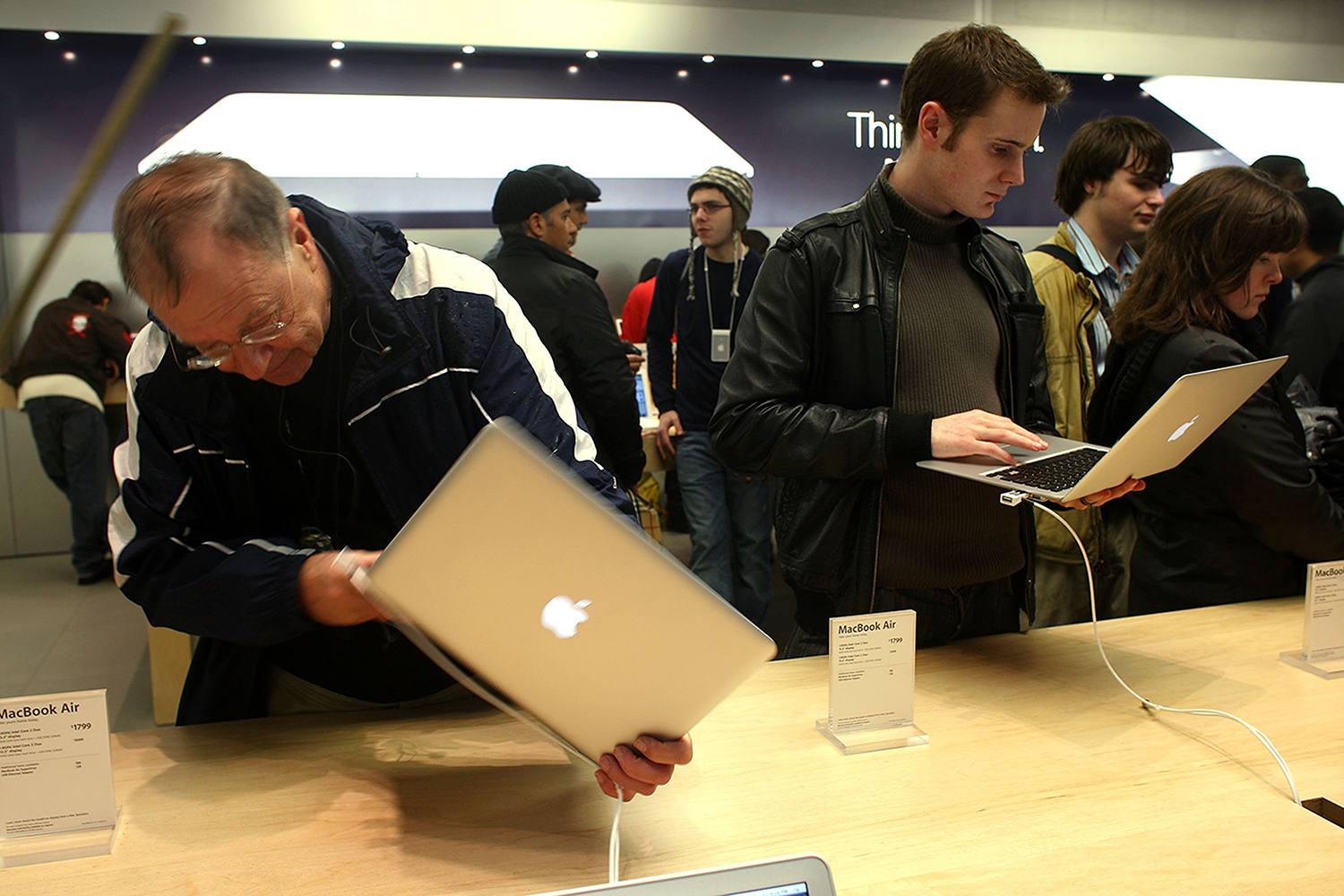 Pessoas segurando e olhando para o MacBook Air na Apple Store