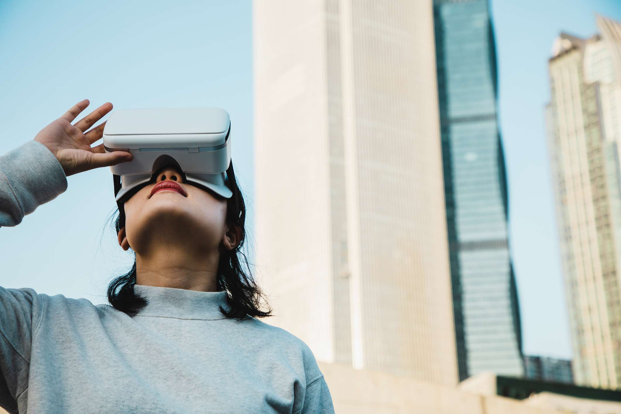 Mulher usando fone de ouvido de realidade virtual na cidade