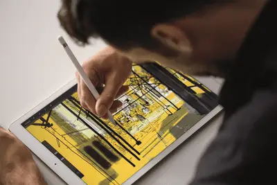 Homem desenhando com a caneta da Apple em um iPad